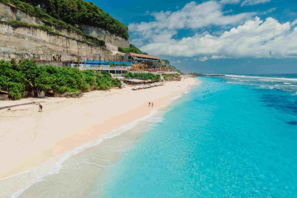 Paradise holiday beach with turquoise ocean and beach club in Bali Aerial view