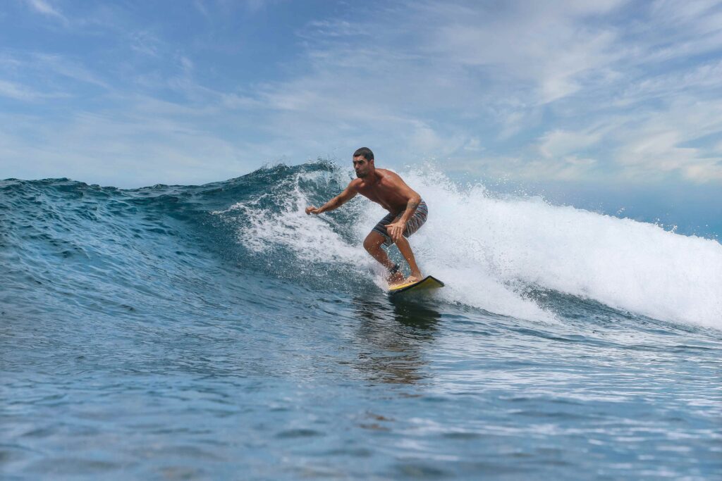 Shirtless male surfer on a wave at sunny day