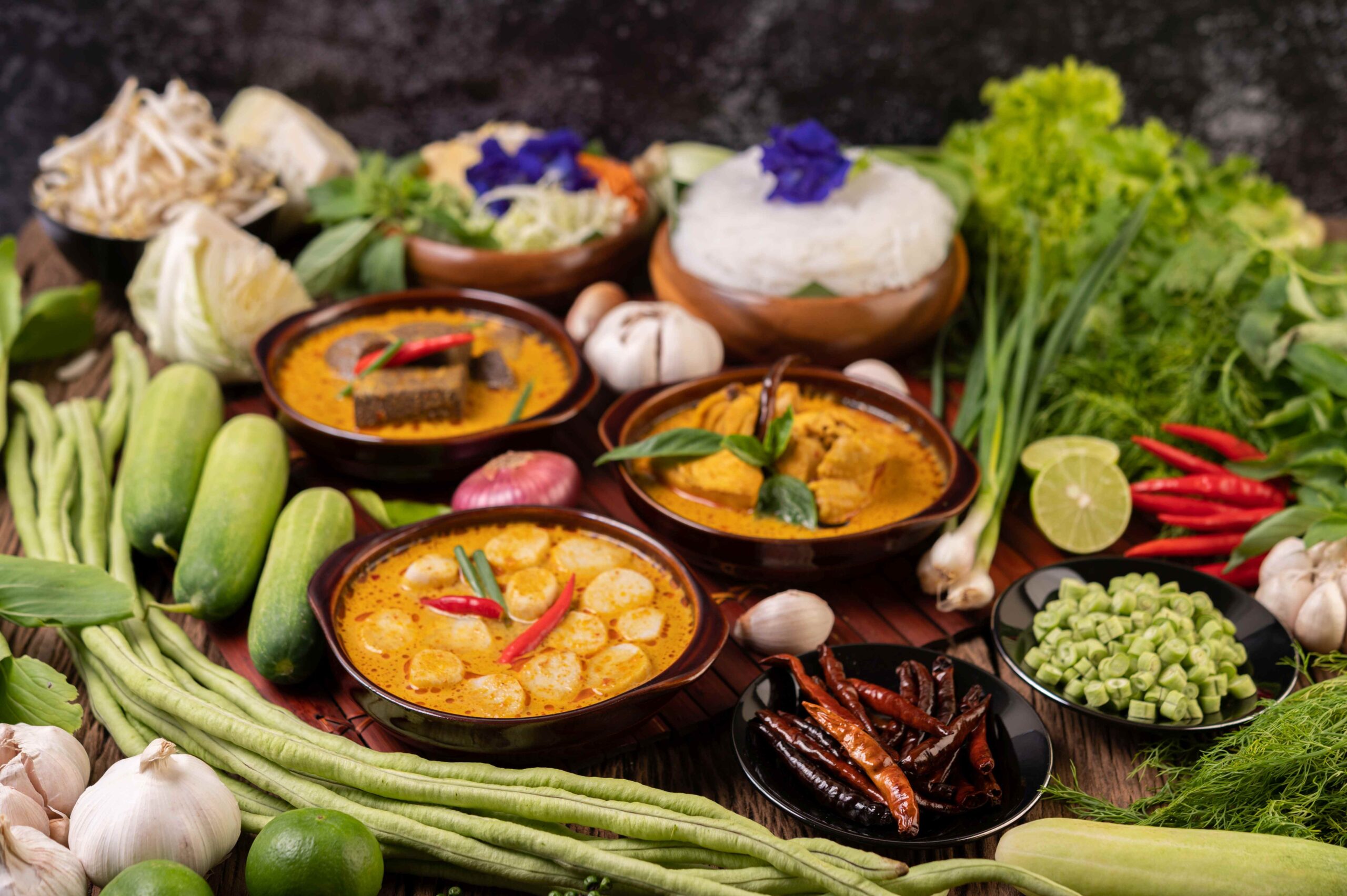 Rice noodles in a bowl of curry paste with chili, cucumber, long