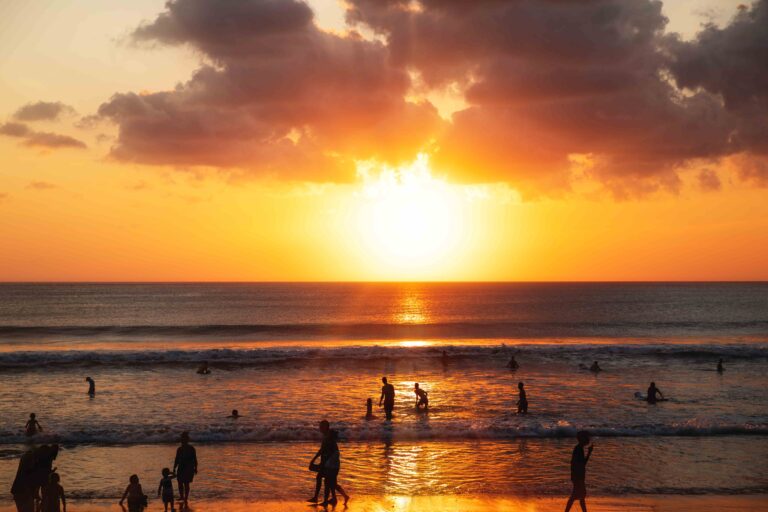 Beautiful sunset and silhouette of different people on the beach