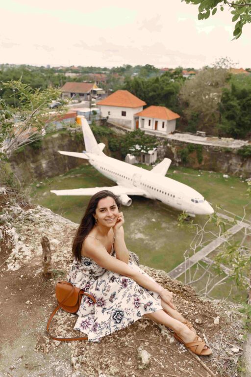 Girl sitting on a rock and looking at a plane