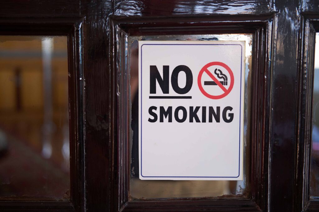 No Smoking sign displayed on a vintage wooden door, health conscious setting