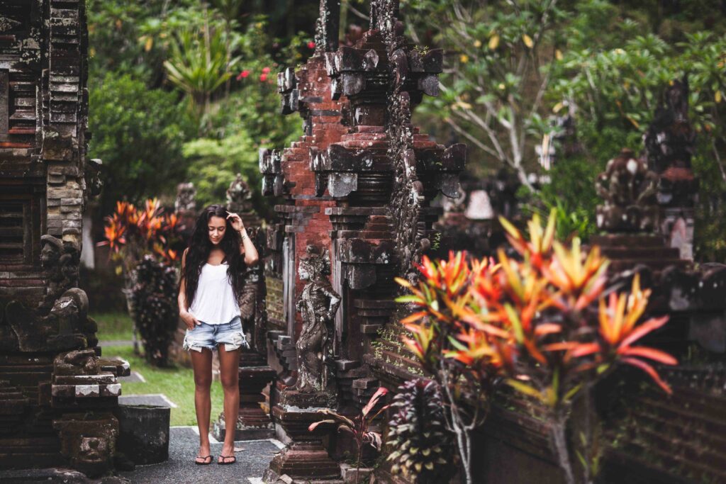 Woma with long black hair surrounded by an old Balinese architec