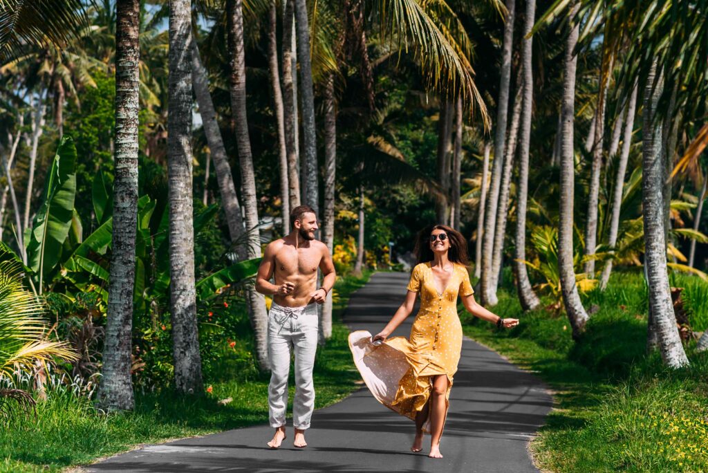 beautiful couple running among palm trees in bali 2023 11 27 05 00 51 utc