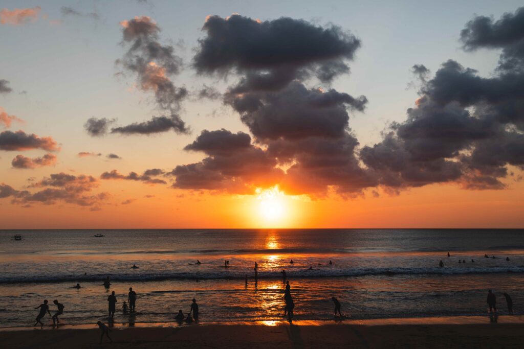 Beautiful sunset and silhouette of different people on the beach