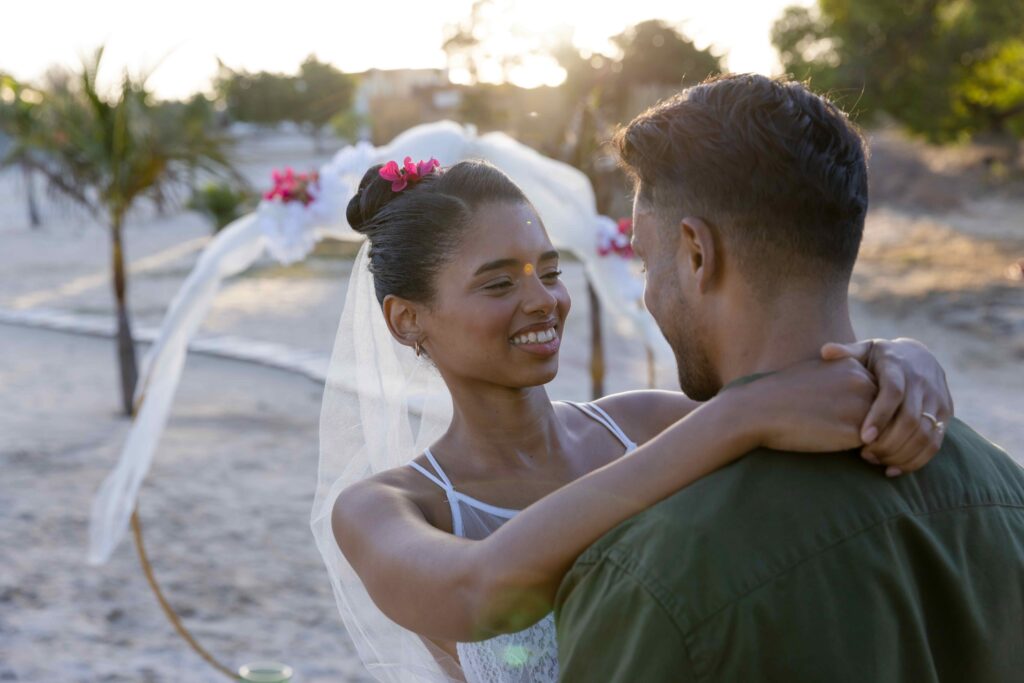 Caucasian newlywed bride embracing and looking at groom at wedding ceremony at beach Unaltered, love, together, destination wedding, event, tradition, celebration, summer, happy, nature and sunset