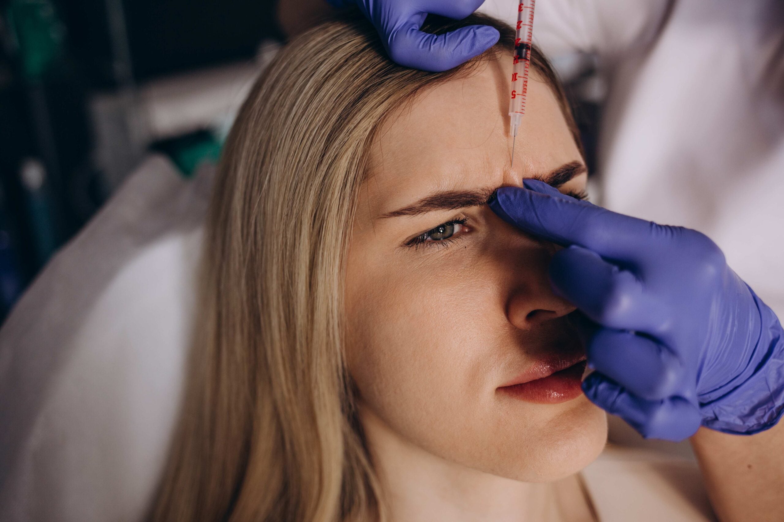 Close up of botox injection in the eyebrow or forehead of female patient