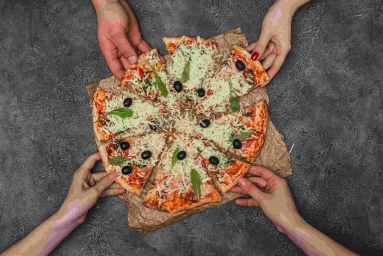Close up view of people hands taking pizza slices on dark background