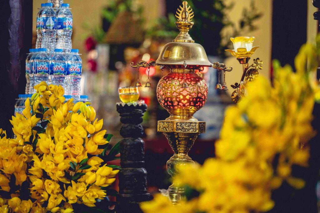 Closeup shot of Buddhist ornaments,water bottles and yellow flowers inside a temple in Vietnam