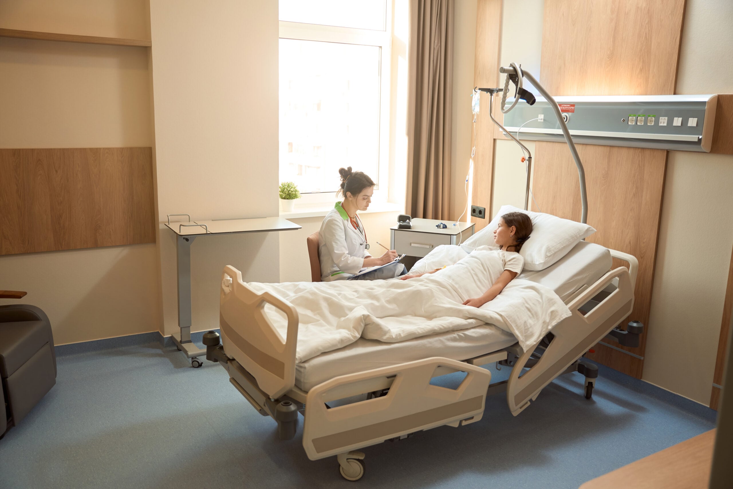 Doctor checks condition of a teenager girl after medical procedures