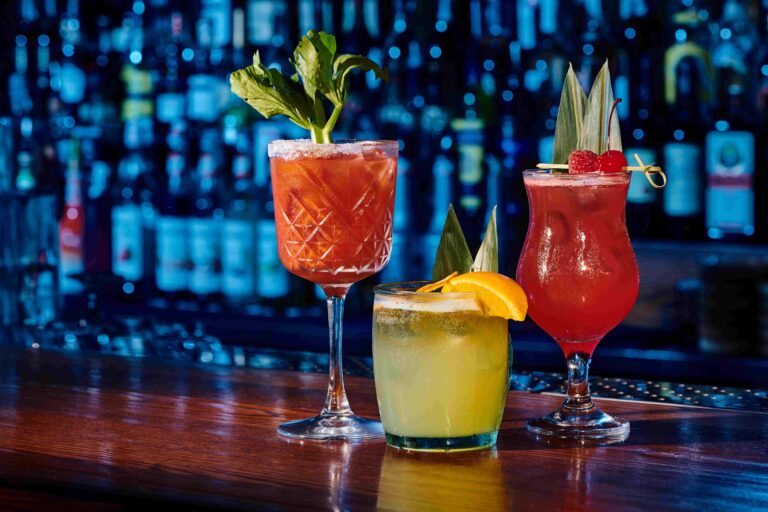 glasses of three different refreshing cocktails with decorations on bar counter, concept