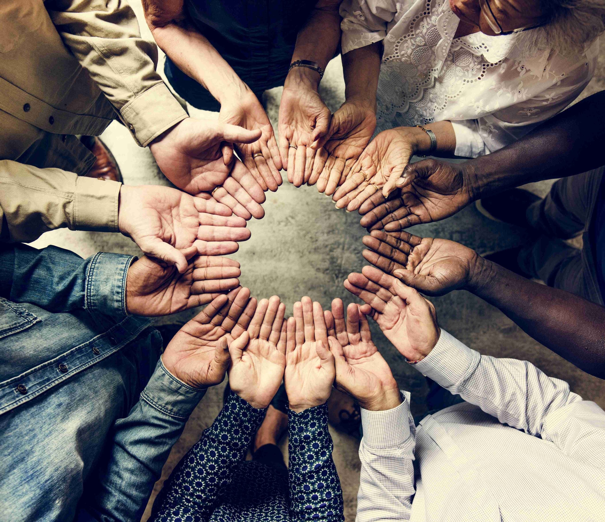Group of diverse hands palms circle support together teamwork aerial view