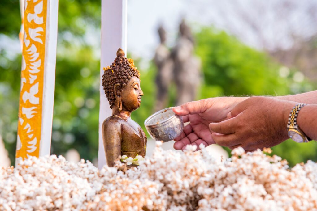 People pour water over Buddha statues