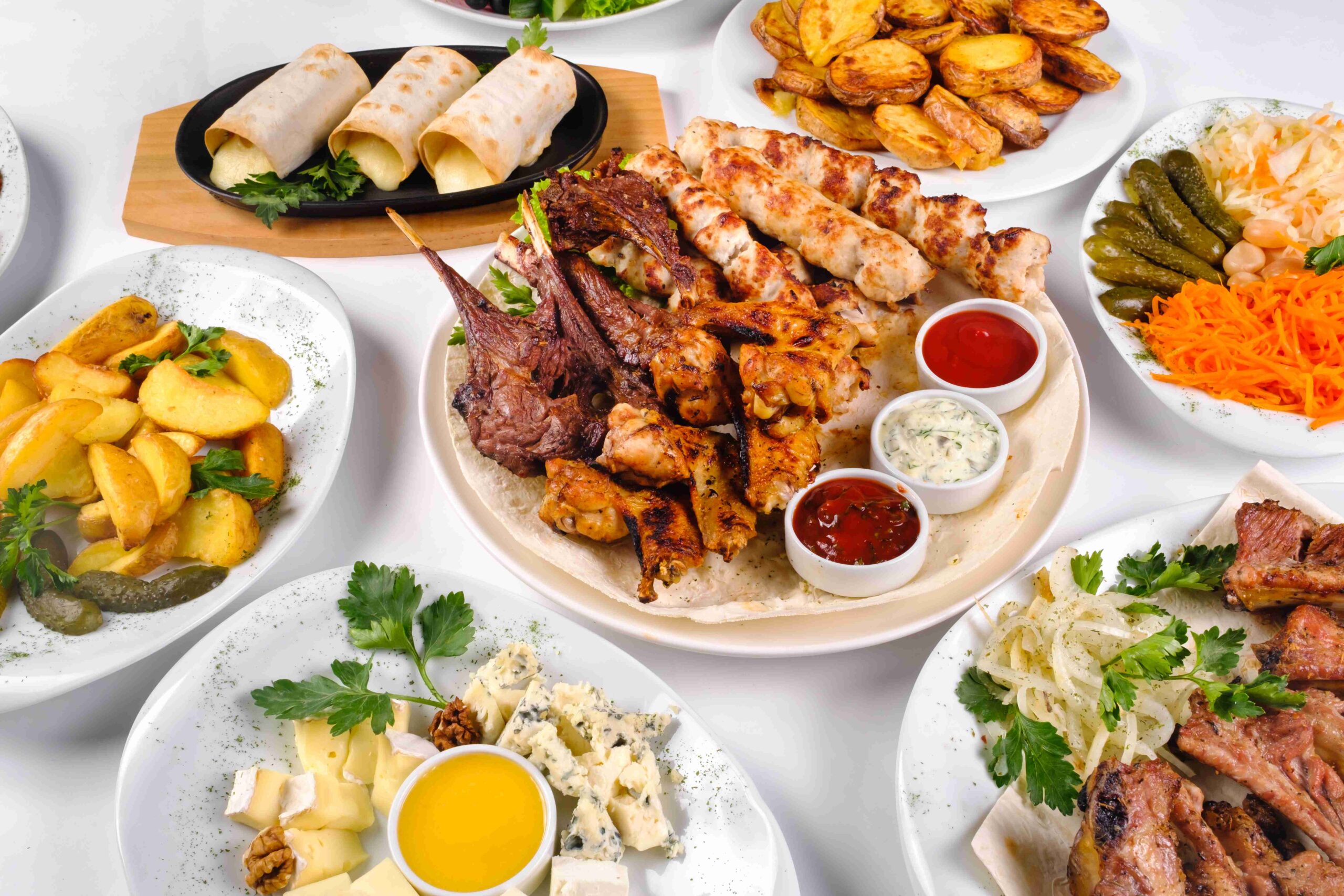 A covered table with many different dinner dishes Lots of food on a white isolated background