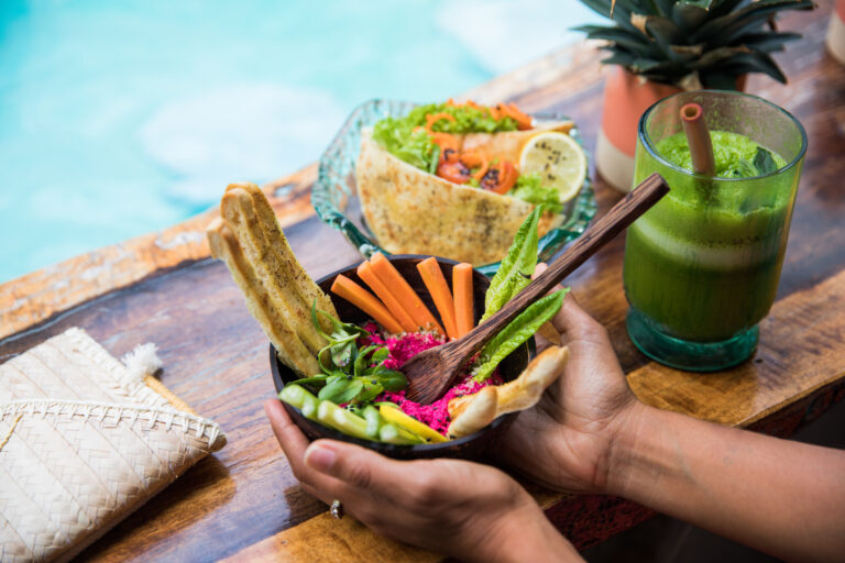 African American lady with fresh salad and shake on table