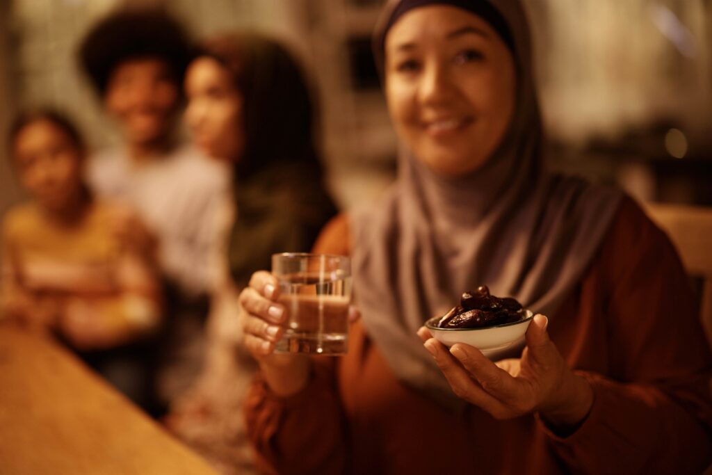 Happy mature Middle Eastern woman celebrating Ramadan with her family and looking at camera