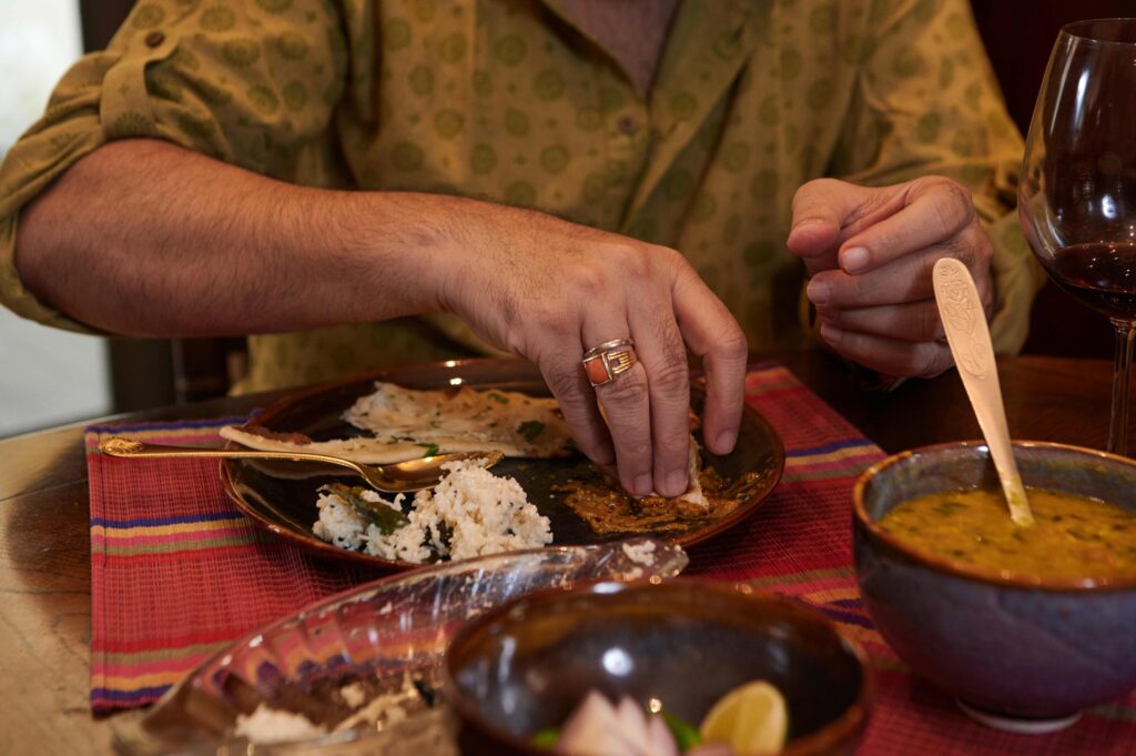 Man Eating Indian Food During Dinner