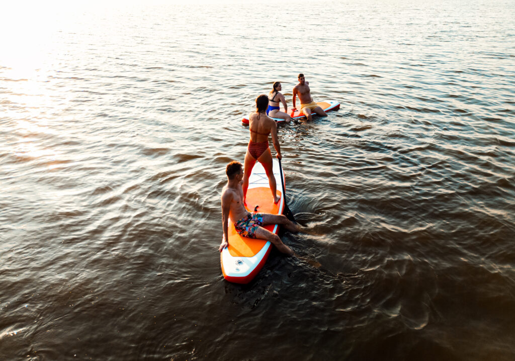 Aerial view of friends on sup board enjoying a day at lake durin