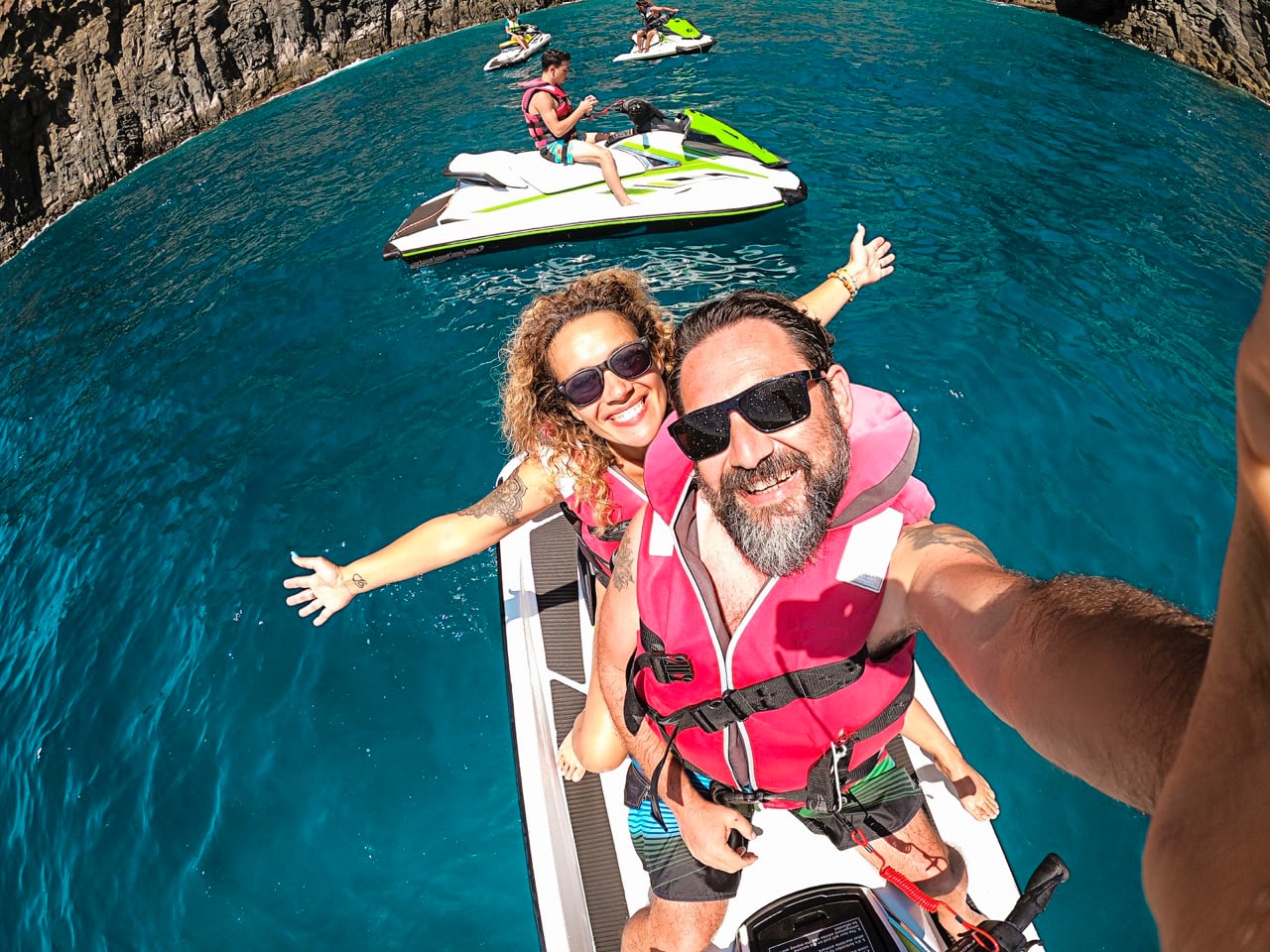 Happy adult couple have fun on jet sky activity escursion in summer holiday vacation at the sea ocean active people take selfie picture and smile with happiness and freedom cheerful lifestyle