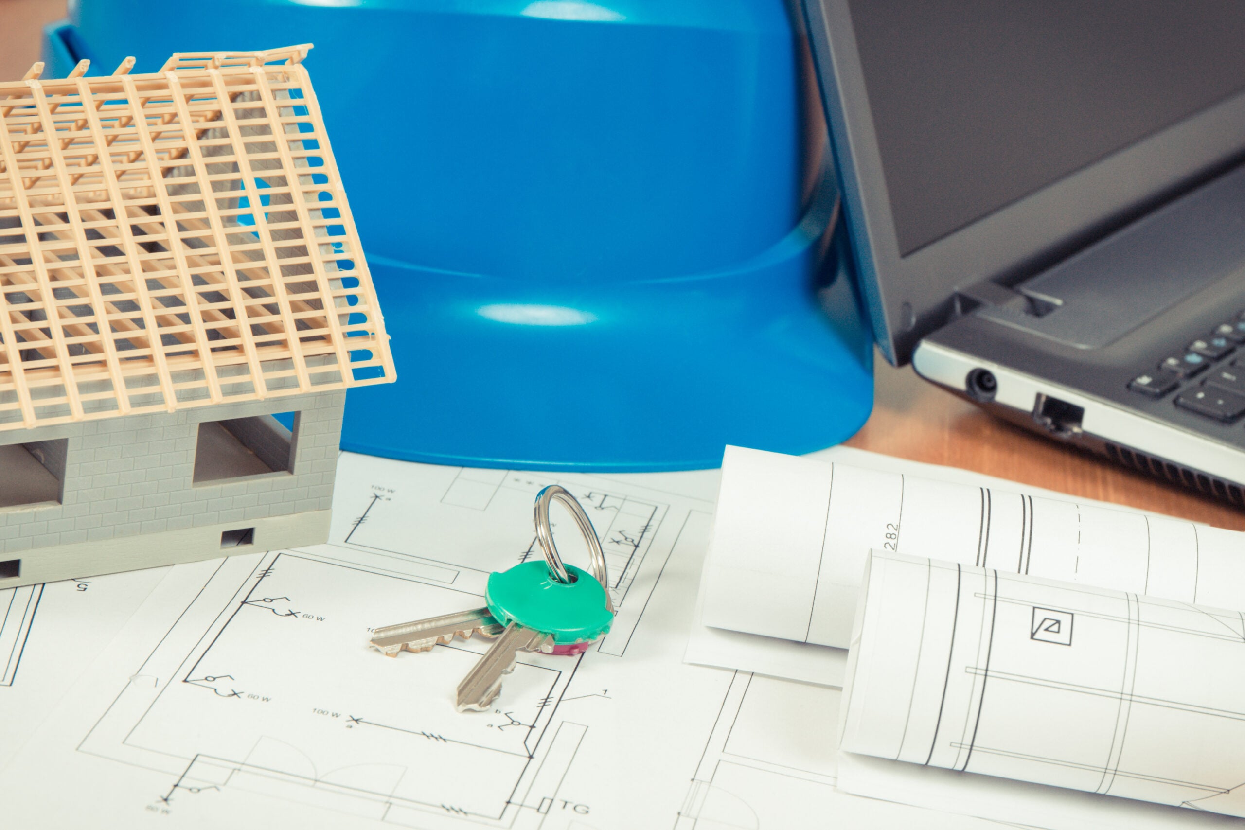 Home keys, small house, electrical diagrams with laptop for engineer jobs, building home concept