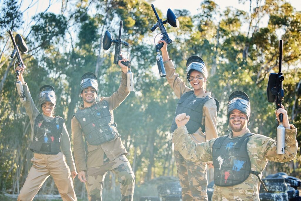 Team, paintball and portrait in celebration for winning, victory or achievement on the battlefield