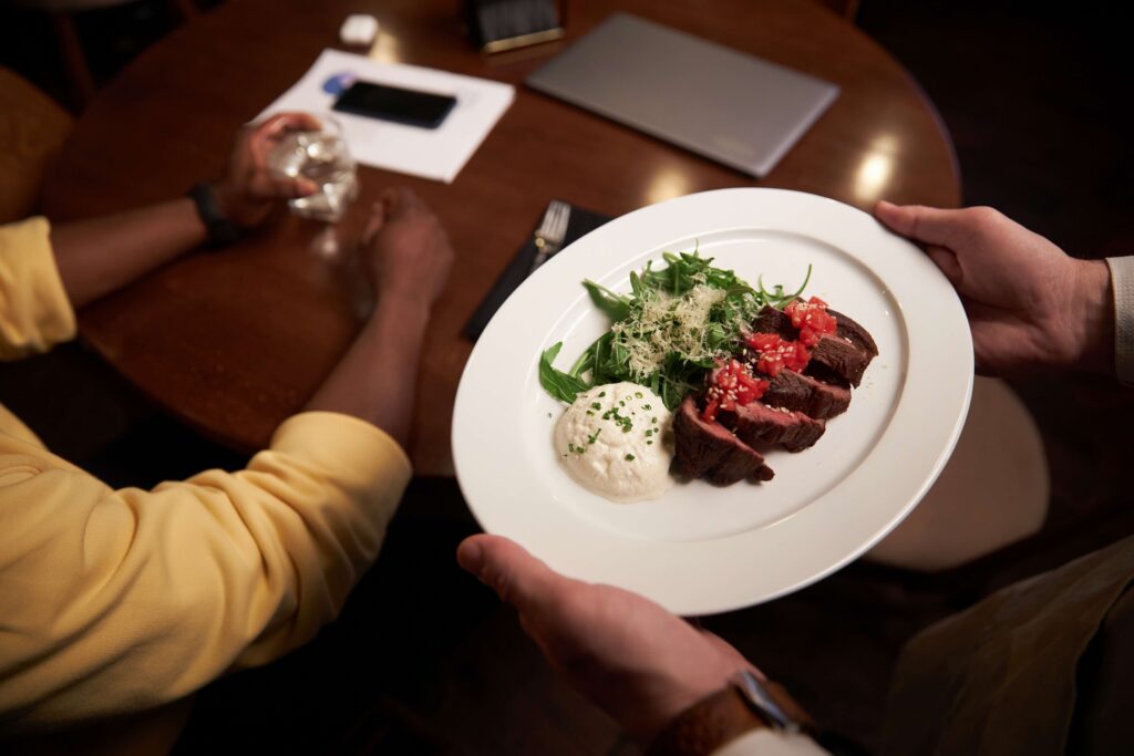 Waiter serving dinner for customer