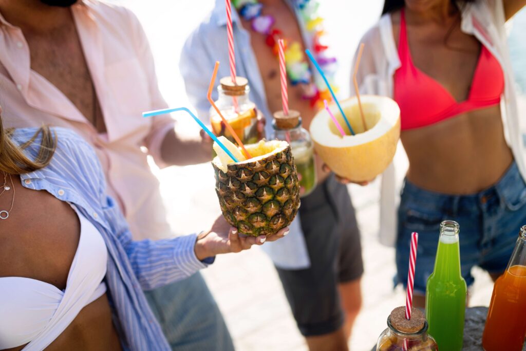 Young group of friends enjoying summer on the beach at sunset