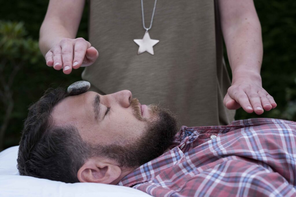 Alternative therapies,United Kingdom,A man on a couch with a stone on his forehead, therapy session