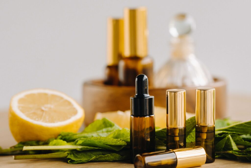 Essential oil in bottles with lemon and mint fragrance lying on a wooden surface