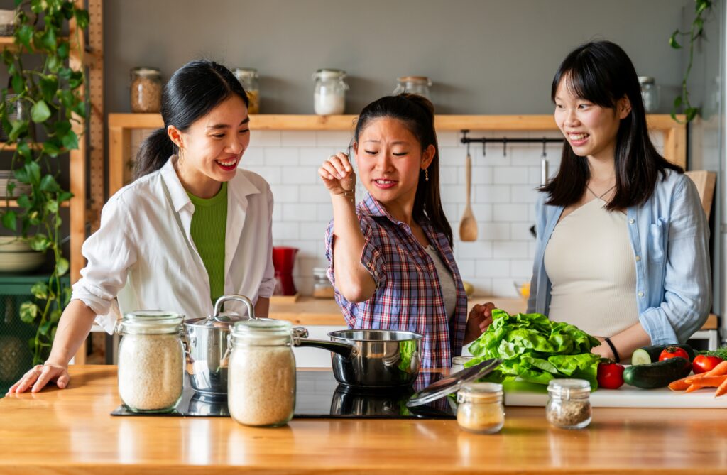 Happy beautiful chinese women friends bonding at home