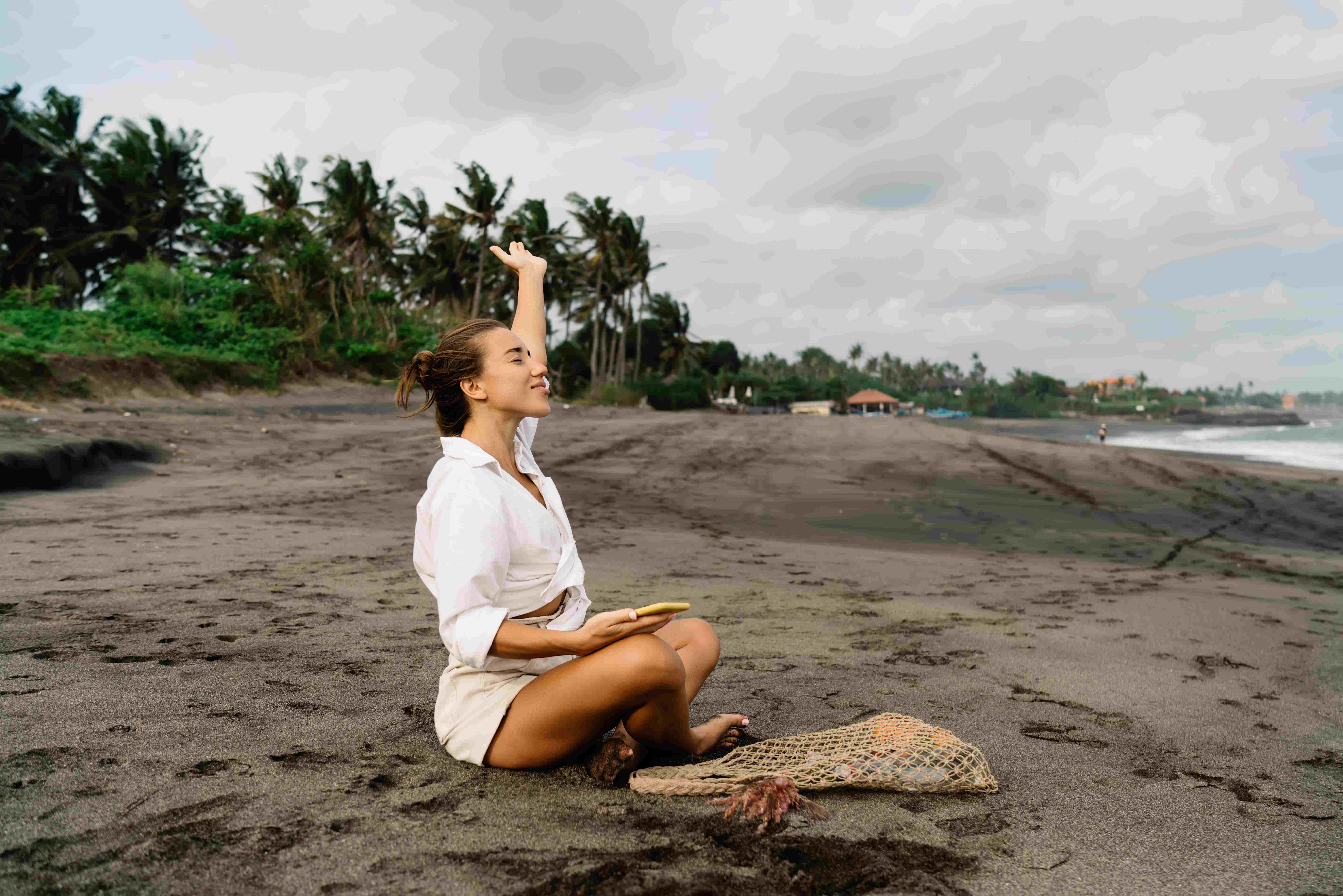 Positive woman on seashore on tropical holiday