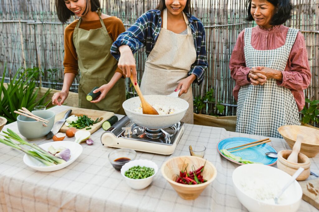 Southeast asian mother with her daughters having fun cooking Tha