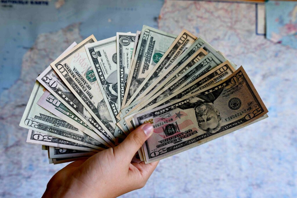 Dollars in the hands Dollar bills Cash US currency Money Map in the backgraund Tourism concept