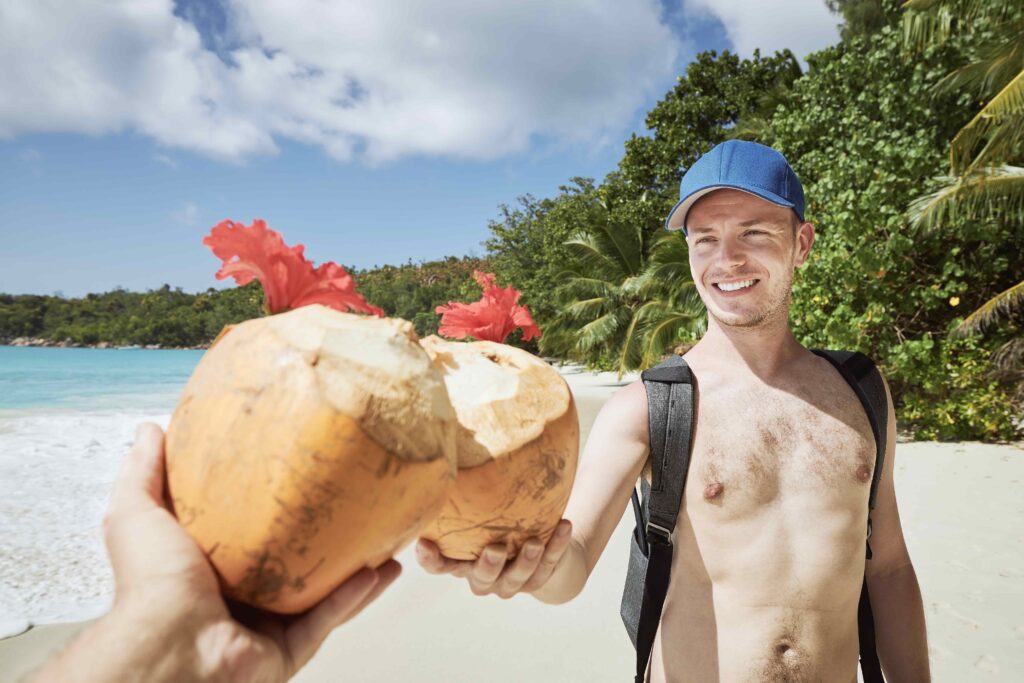 Friends drinking coconut drink together on beach