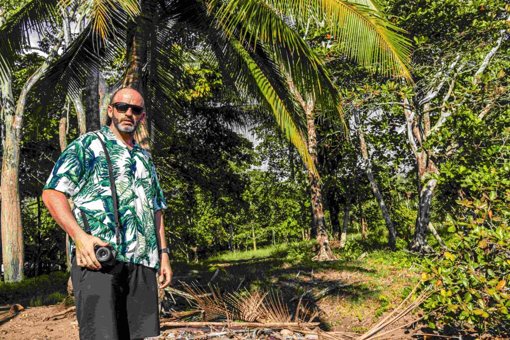 Man carrying a digital camera on a tropical surrounding