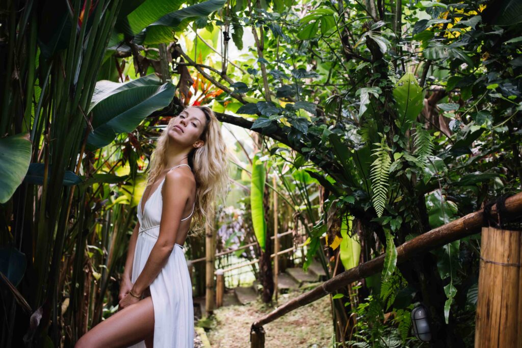 Stylish woman standing in tropical woods