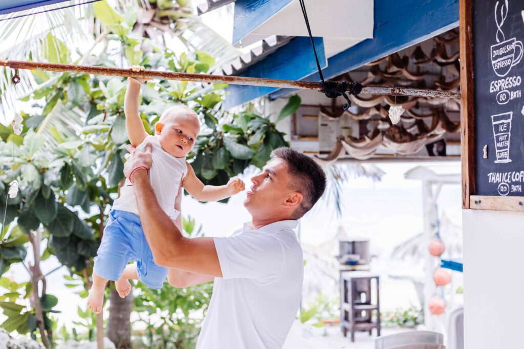 Happy father with little baby boy nine months old on vacation in tropical country