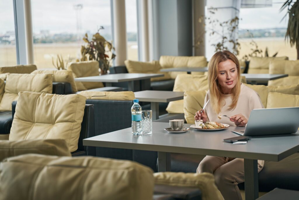 Focused female staring at her laptop screen at breakfast