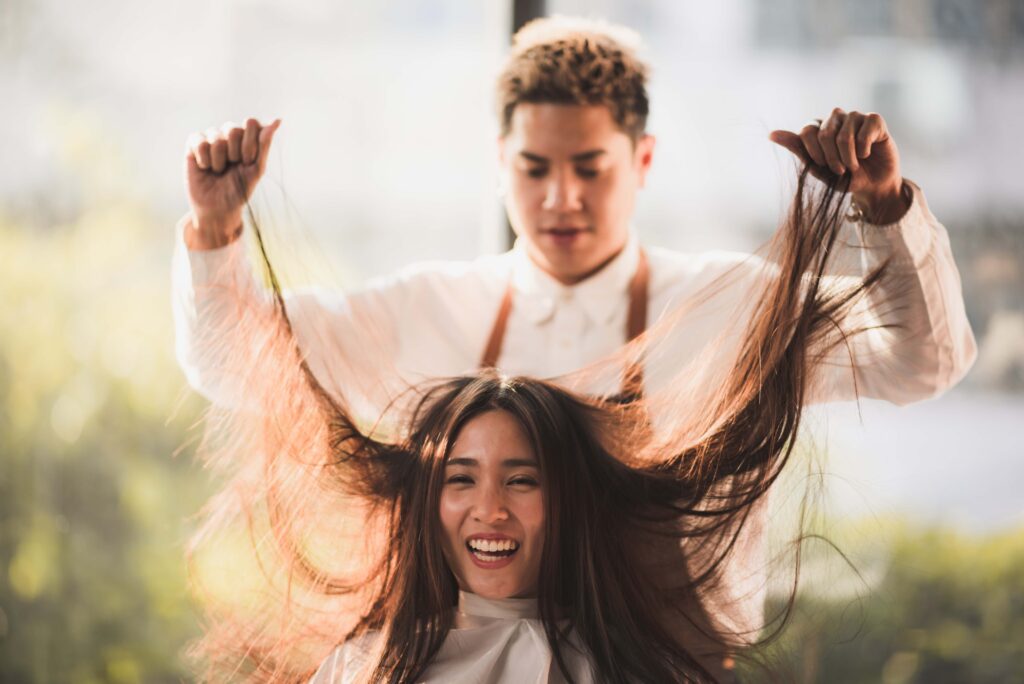 Hairdresser is styling the client's hair hair setting at salon, beauty concept brown hair