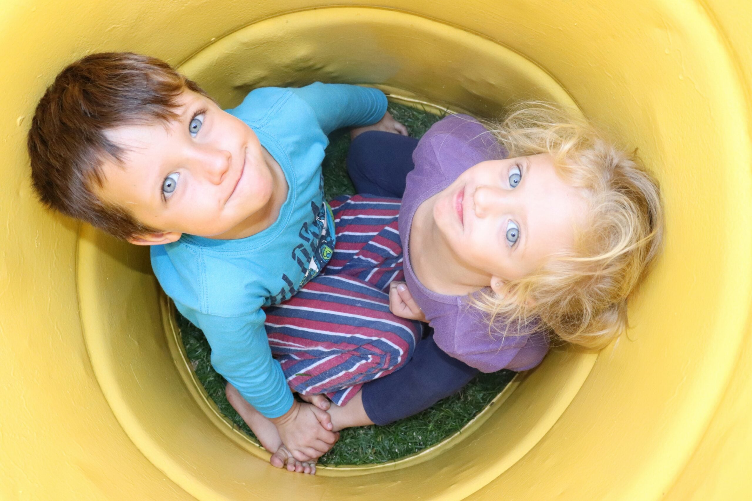 girl-in-blue-and-black-stripe-long-sleeve-shirt-on-yellow-plastic-container