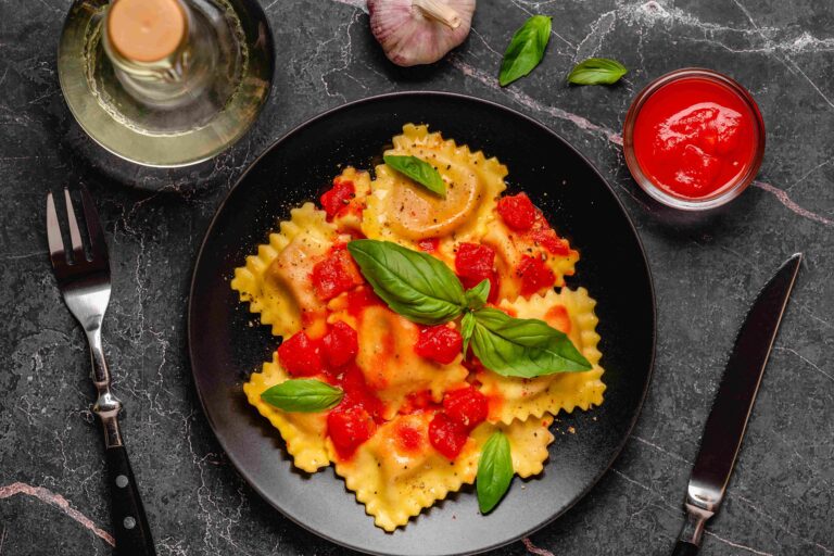 Delicious appetizing ravioli with tomato sauce and basil