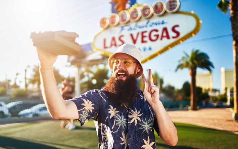 retro vegas tourist taking selfie with vintage instant film camera on the strip