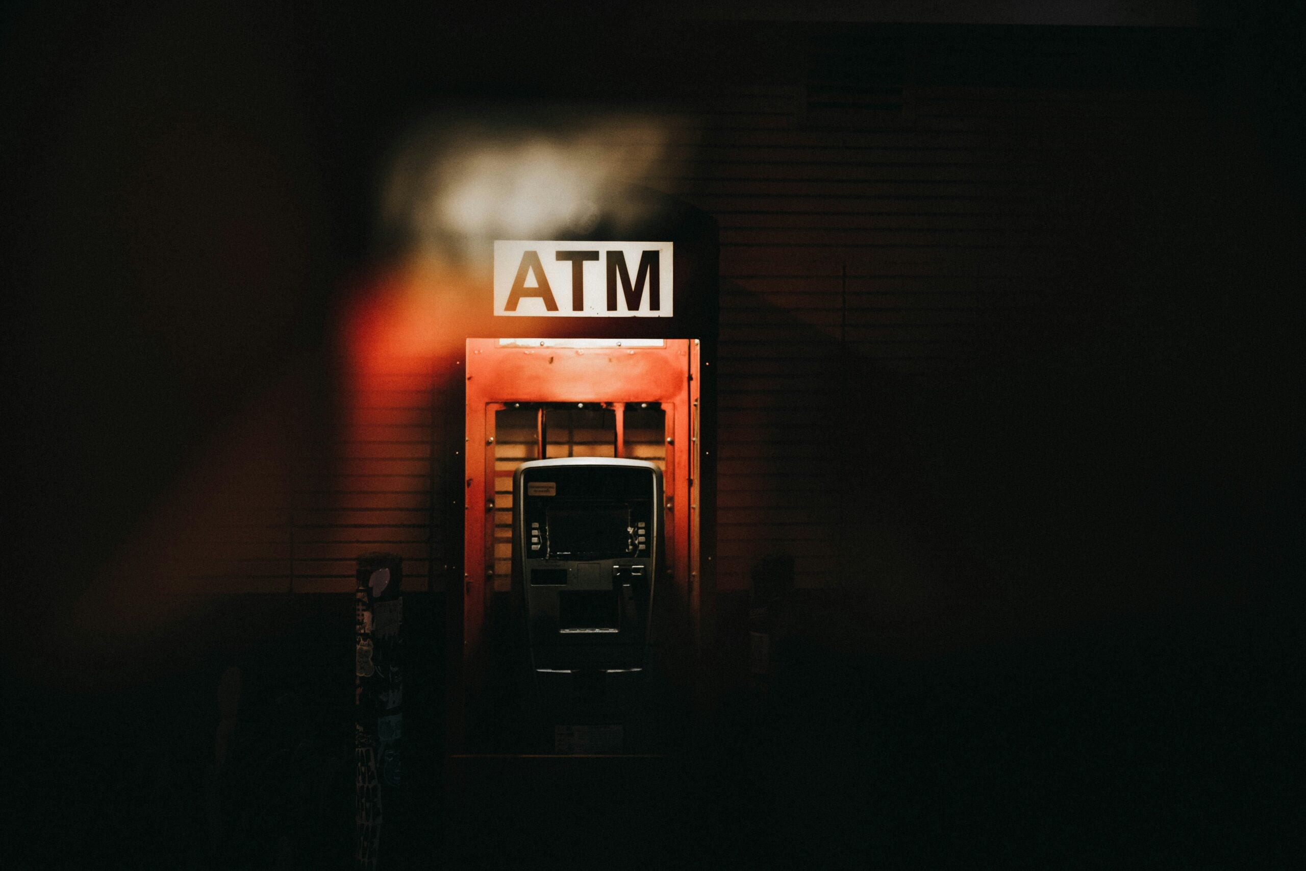 a-building-with-a-atm-sign-lit-up-at-night