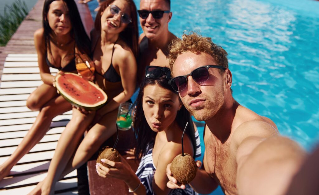 Holding watermelon Group of young happy people have fun in swimming pool at daytime