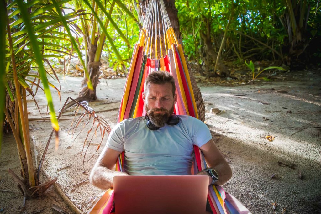 man working on laptop on exotic beach