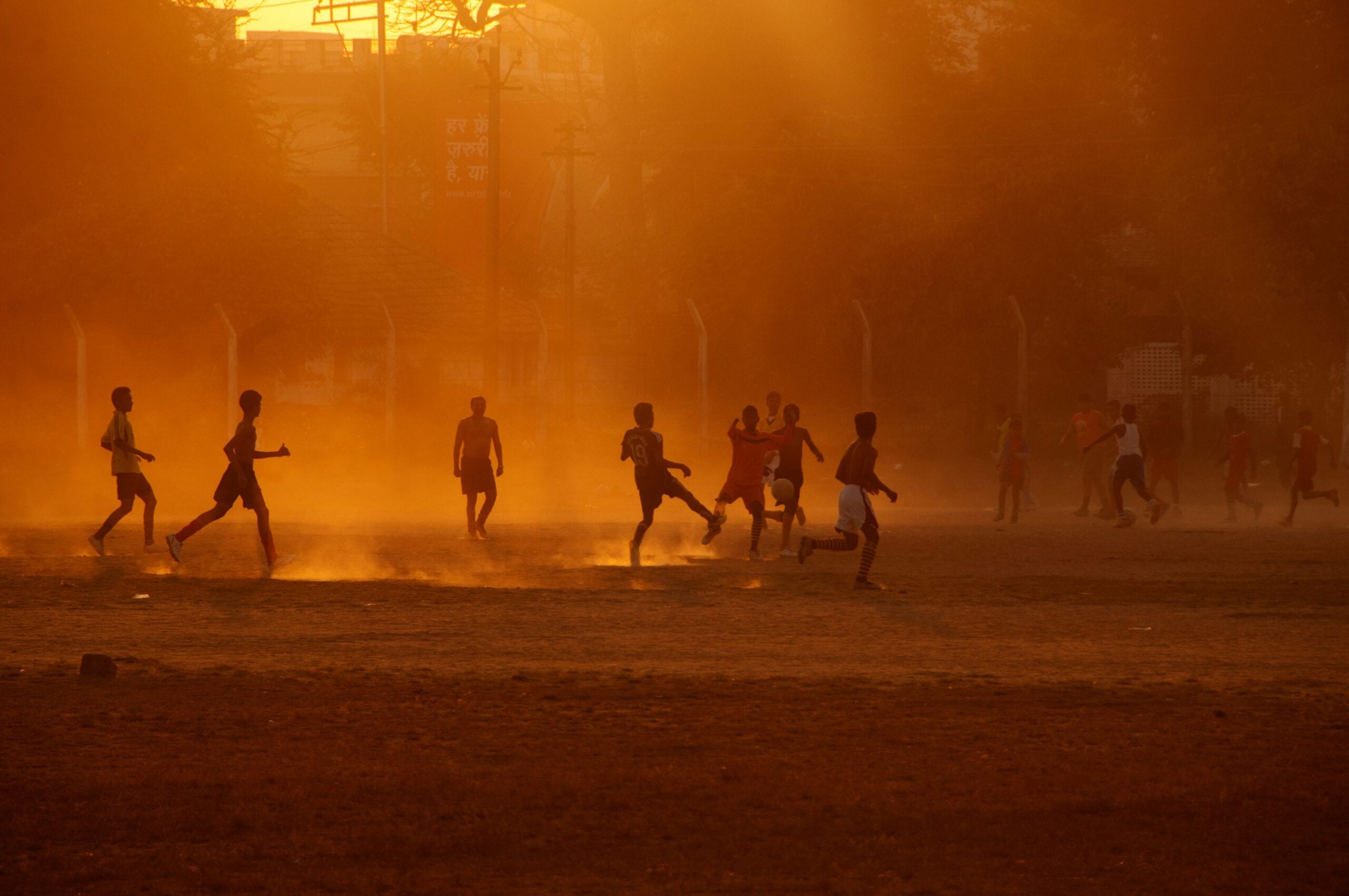 Silhouette people playing football