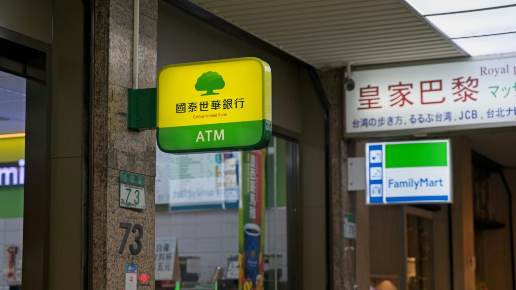 a-green-and-yellow-atm-sign-on-a-building