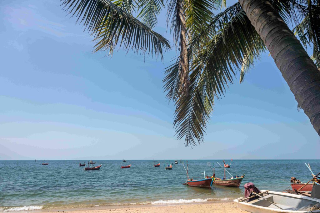 Tropical sea with coconut trees and fishing boat