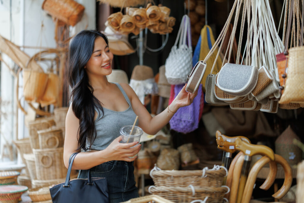 Tourist choosing handmade bag at local market in southeast asia