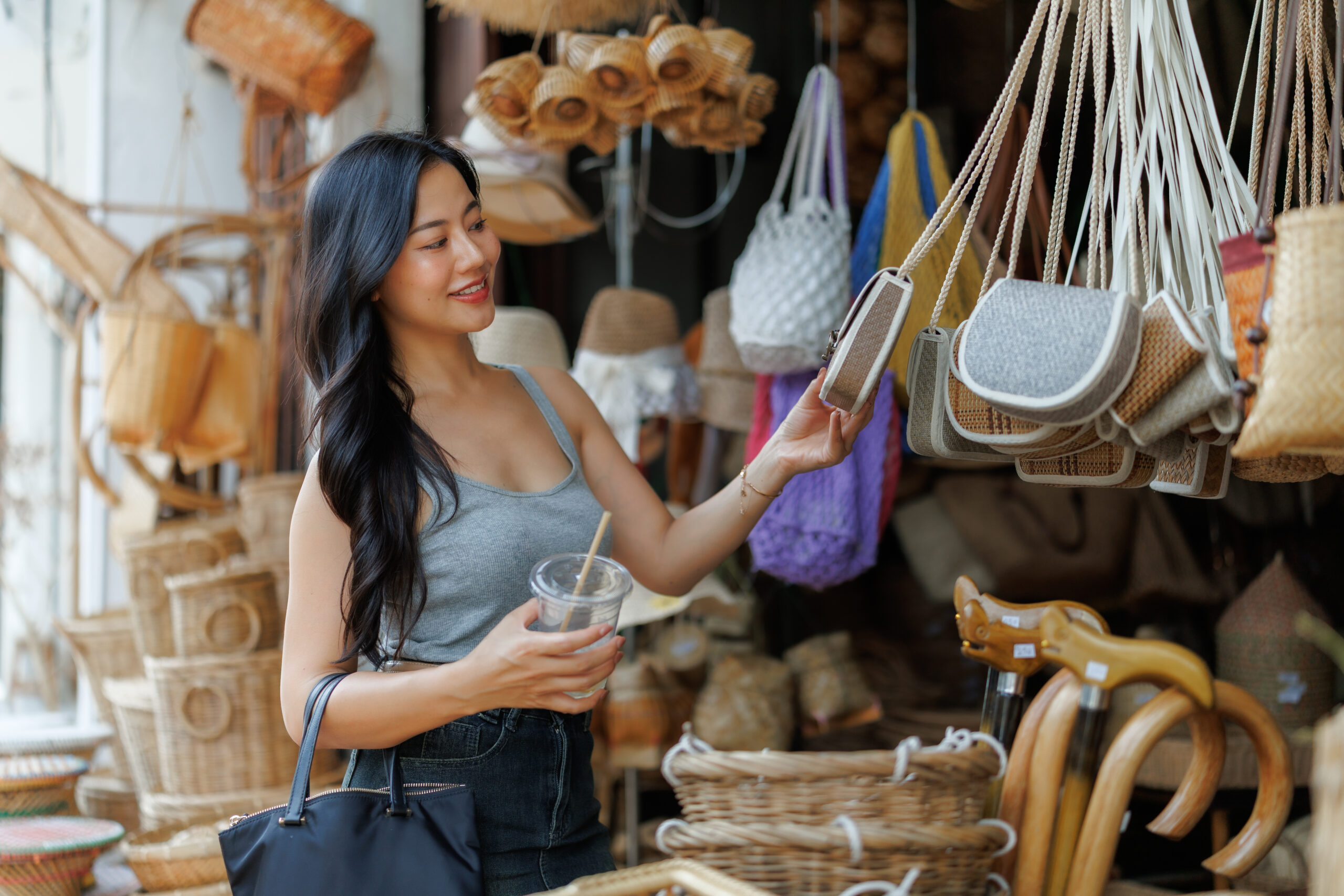 Tourist choosing handmade bag at local market in southeast asia